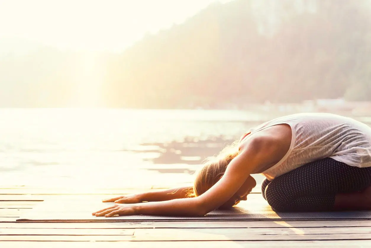 A woman is doing yoga on the ground