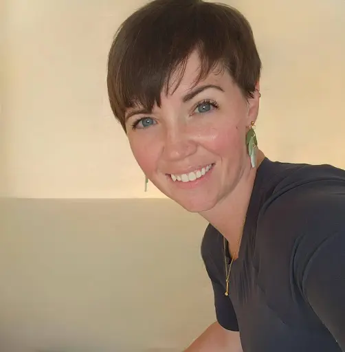 A woman with short hair smiles for the camera.