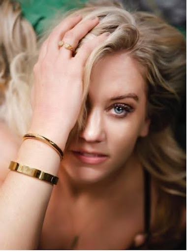 A woman with long blonde hair wearing a gold bracelet.