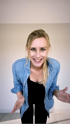 A woman in a blue shirt smiling for the camera.