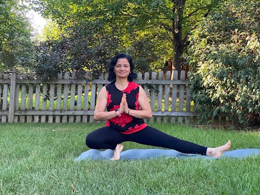 A woman is doing yoga in the grass