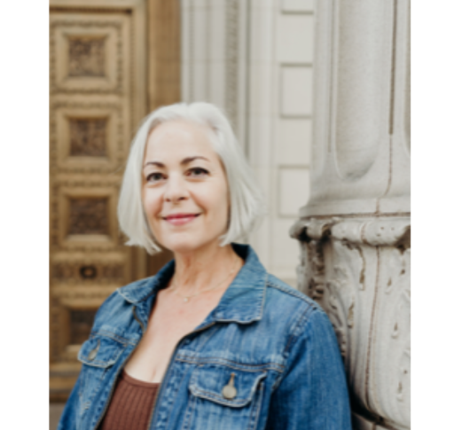 A woman with white hair wearing a jean jacket.