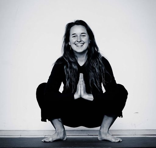 A woman squatting in the middle of her yoga pose.