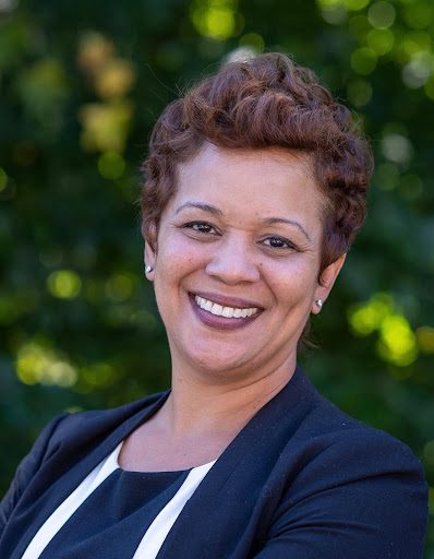 Woman smiling in a black blazer.