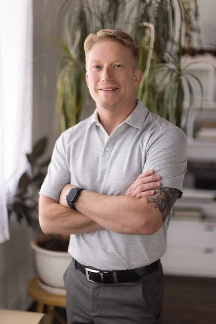 Man in grey shirt with arms crossed.