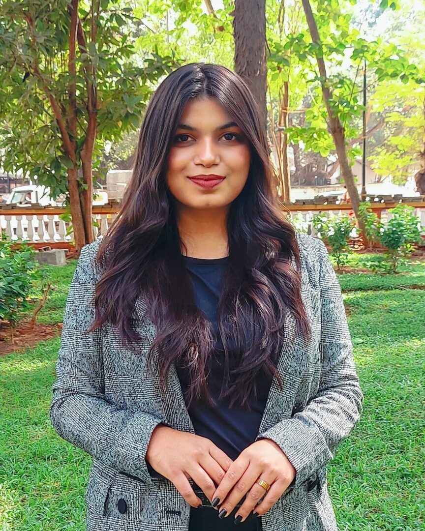 Woman in a gray blazer with long hair.