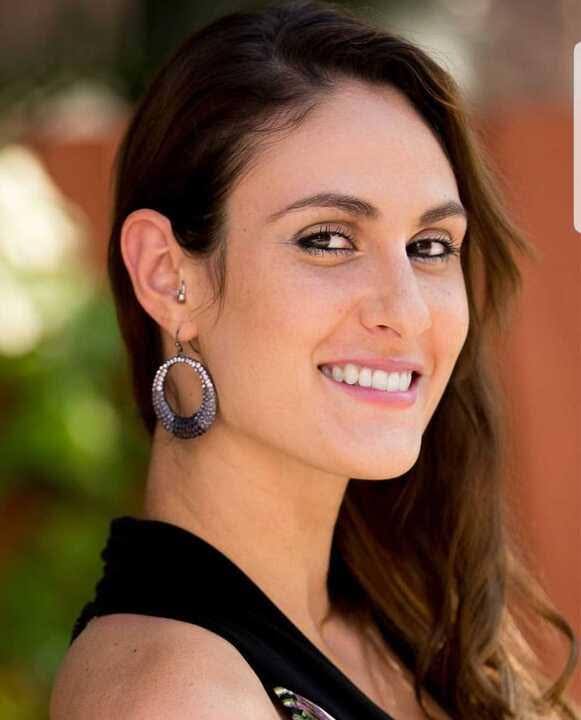 Woman smiling with large hoop earrings.