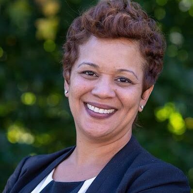 Woman smiling in a black blazer.