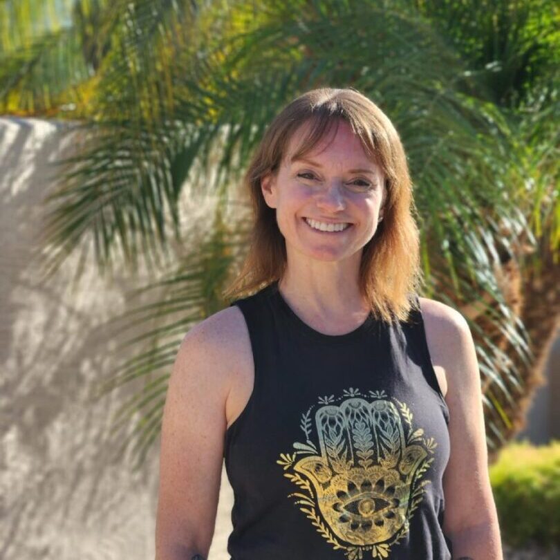 A woman standing in front of some trees