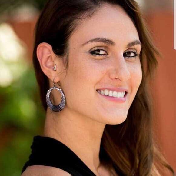 Woman smiling with large hoop earrings.