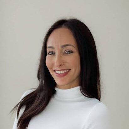 A woman in white shirt smiling for the camera.