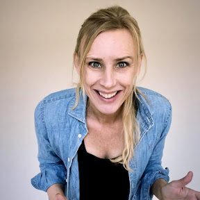 A woman in a blue shirt smiling for the camera.