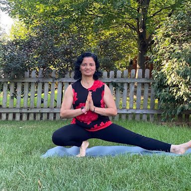 A woman is doing yoga in the grass