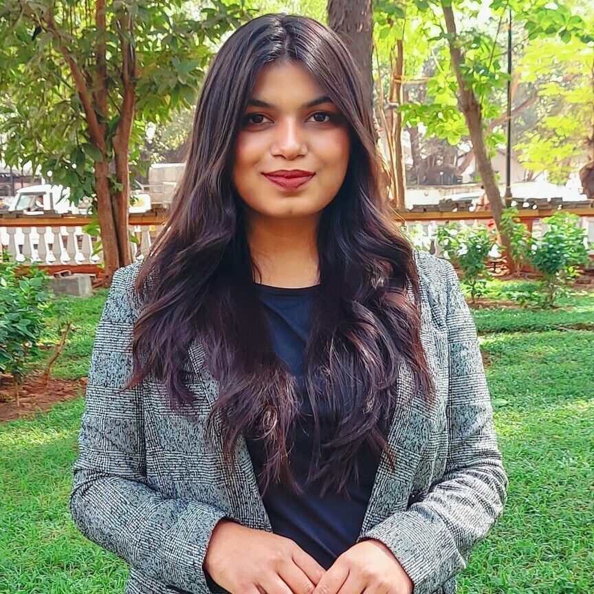 Woman in a gray blazer with long hair.