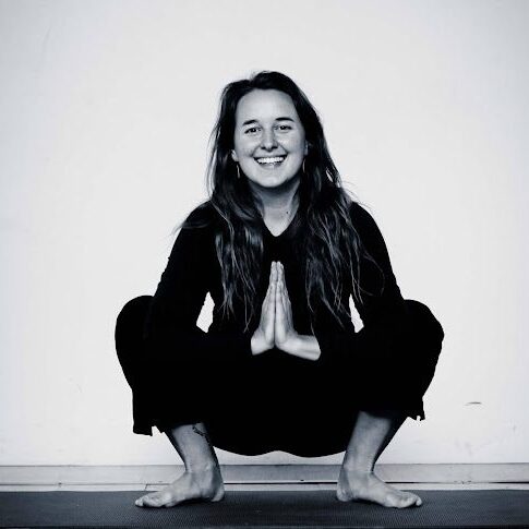 A woman squatting in the middle of her yoga pose.